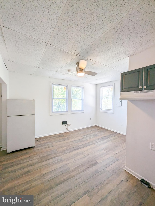 5200 Ballman, Brooklyn, MD 21225 - unfurnished living room featuring baseboards, wood finished floors, ceiling fan, and a drop ceiling
