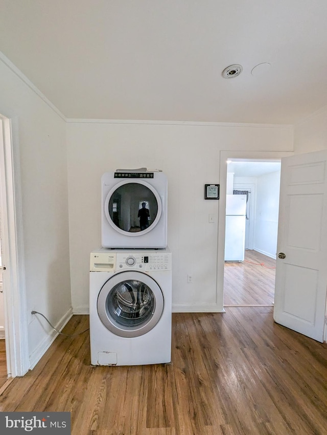 5200 Ballman, Brooklyn, MD 21225 - washroom featuring baseboards, stacked washer and clothes dryer, wood finished floors, and laundry area