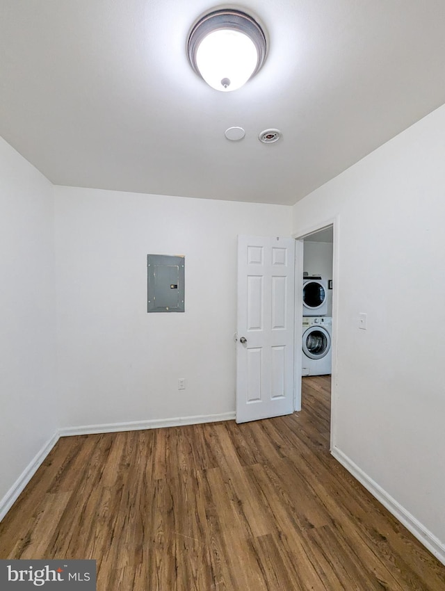 5200 Ballman, Brooklyn, MD 21225 - washroom with electric panel, stacked washer and clothes dryer, laundry area, baseboards, and wood finished floors