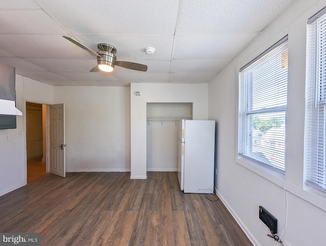5200 Ballman, Brooklyn, MD 21225 - unfurnished bedroom featuring dark wood-style floors, baseboards, freestanding refrigerator, a closet, and a drop ceiling