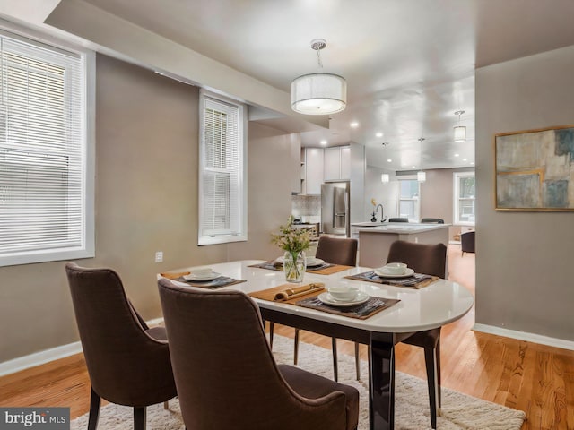 dining room with light hardwood / wood-style floors and sink