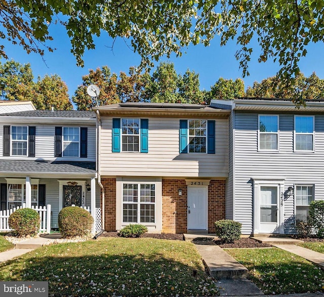 townhome / multi-family property with a porch and a front lawn