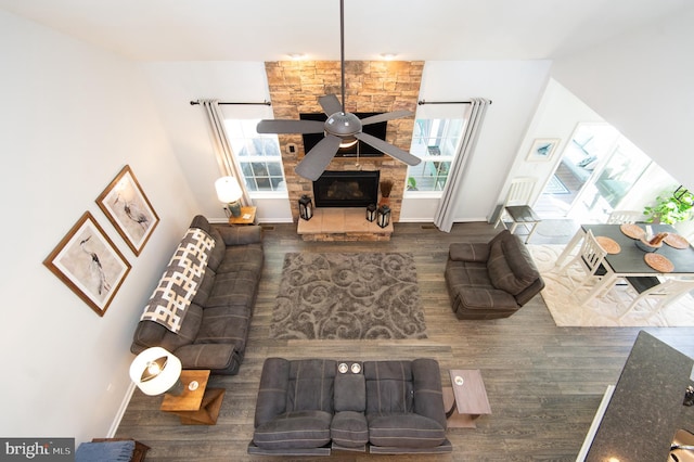 living room featuring hardwood / wood-style floors, a stone fireplace, and ceiling fan