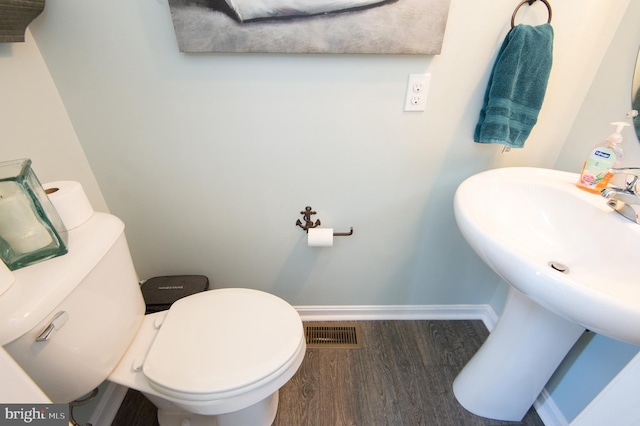 bathroom featuring hardwood / wood-style flooring and toilet