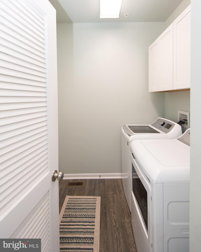 laundry area featuring cabinets, dark hardwood / wood-style floors, and independent washer and dryer