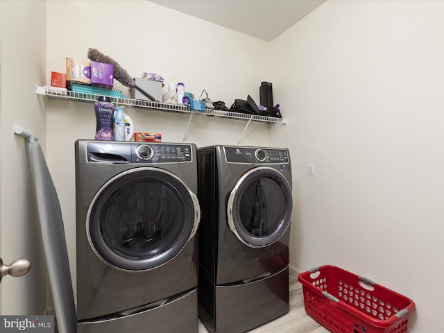 washroom with washing machine and dryer and wood-type flooring