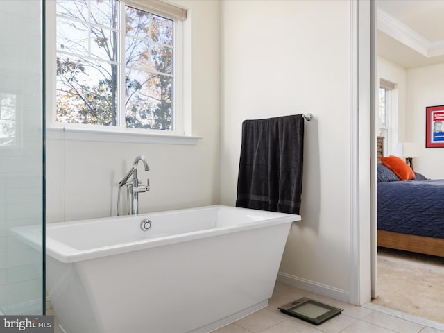 bathroom with ornamental molding, a bath, and plenty of natural light