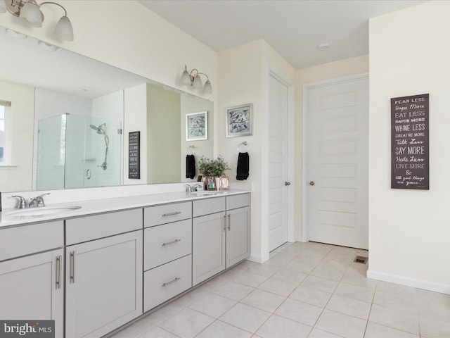 bathroom featuring vanity, a shower with shower door, and tile patterned flooring