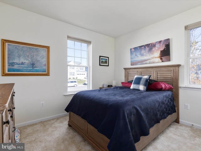 bedroom featuring light carpet and multiple windows