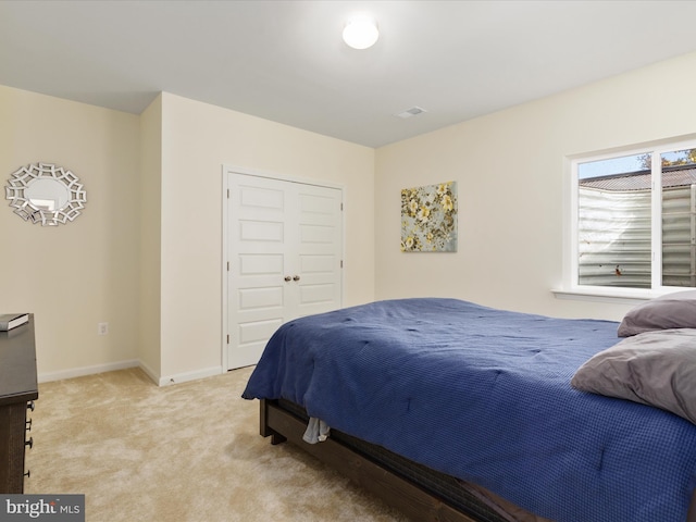 bedroom with light colored carpet and a closet