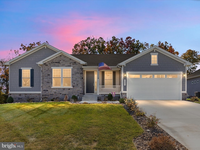 view of front of house with a yard, a garage, and central air condition unit