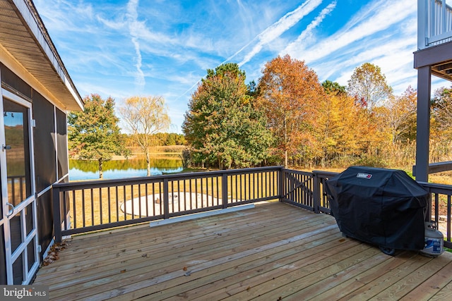 deck with a water view and area for grilling