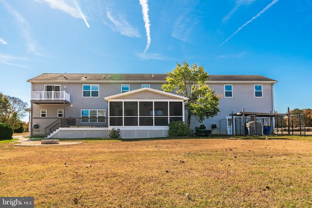 rear view of property with a lawn and a sunroom