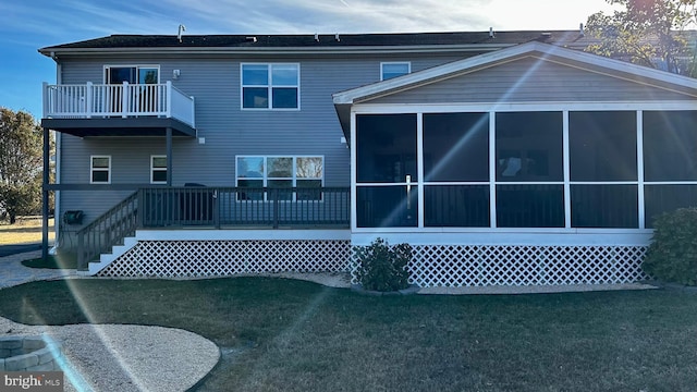 rear view of property with a sunroom and a balcony