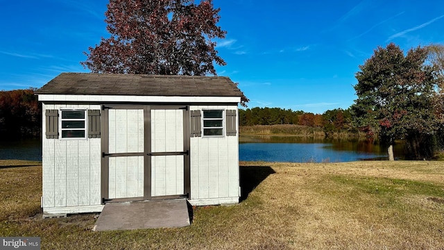 view of outdoor structure featuring a lawn and a water view