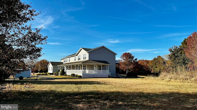 exterior space featuring covered porch and a front yard