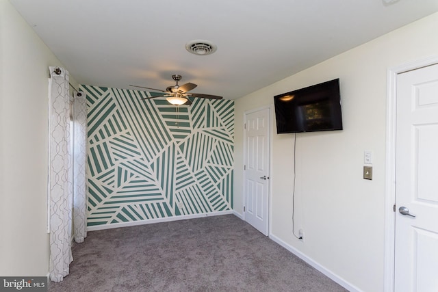 unfurnished room with ceiling fan and carpet