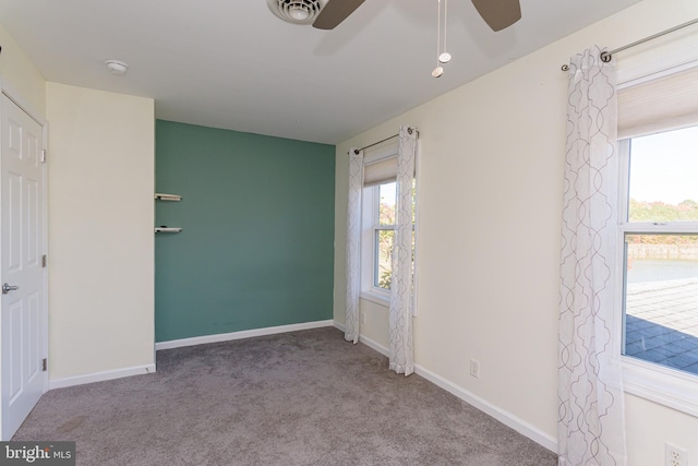 spare room featuring ceiling fan, a healthy amount of sunlight, and carpet flooring