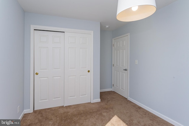 unfurnished bedroom featuring carpet and a closet