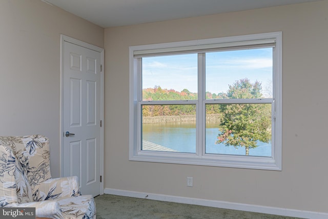 unfurnished room with a water view and carpet floors