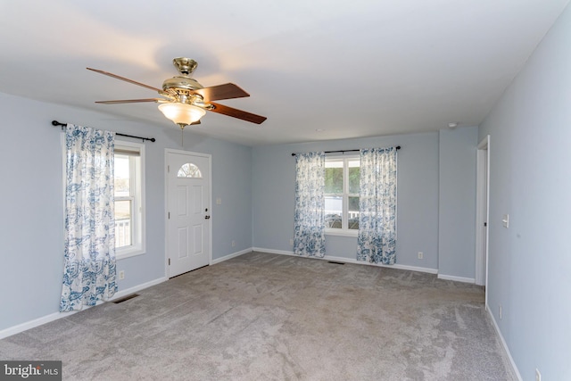 carpeted spare room featuring ceiling fan