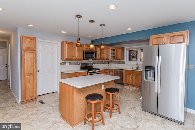 kitchen with stainless steel appliances, a center island, sink, tasteful backsplash, and pendant lighting