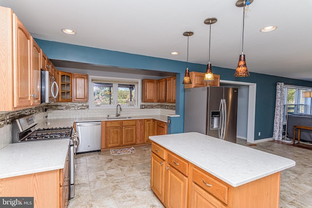 kitchen featuring tasteful backsplash, stainless steel appliances, a kitchen island, pendant lighting, and sink