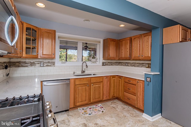 kitchen featuring tasteful backsplash, appliances with stainless steel finishes, sink, and ceiling fan