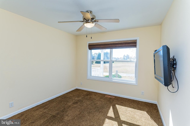 empty room featuring ceiling fan and carpet