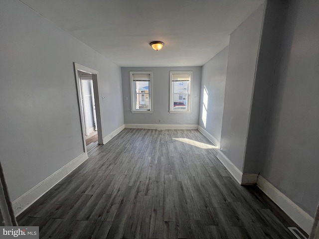 unfurnished room with dark hardwood / wood-style flooring