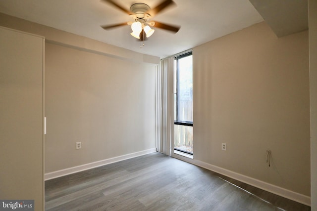 unfurnished room with ceiling fan and dark hardwood / wood-style flooring