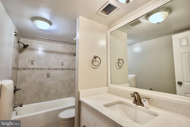 full bathroom with vanity, tiled shower / bath combo, and toilet