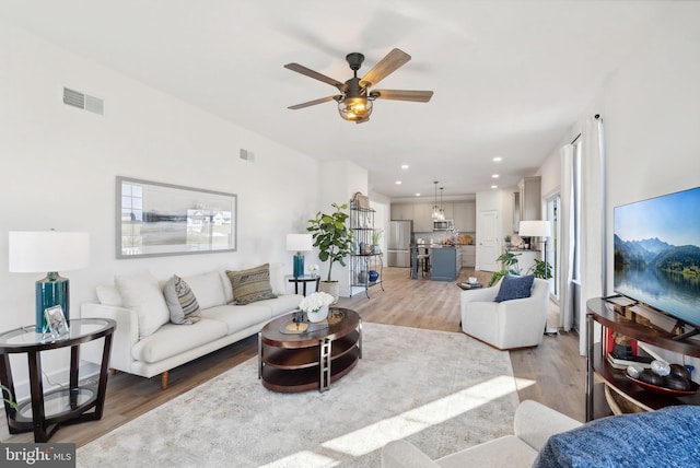 living room with light hardwood / wood-style floors and ceiling fan