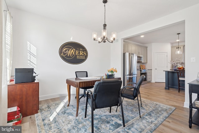 dining area featuring light hardwood / wood-style flooring and a chandelier