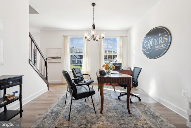 office space featuring wood-type flooring and an inviting chandelier