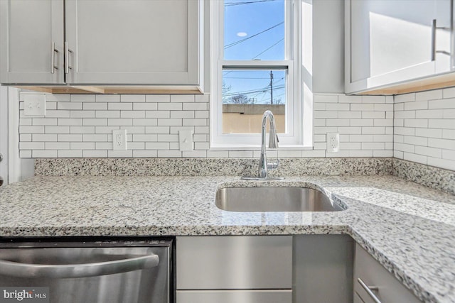 kitchen featuring sink, decorative backsplash, and gray cabinetry