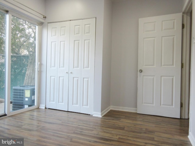 unfurnished bedroom with dark hardwood / wood-style flooring and a closet