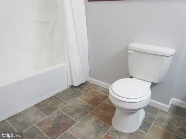 bathroom with toilet and shower / bath combo with shower curtain