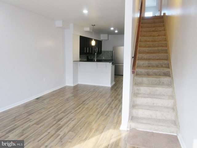 stairway with wood-type flooring and sink