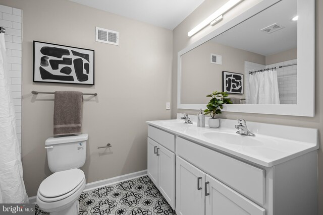 bathroom featuring tile patterned flooring, vanity, and toilet