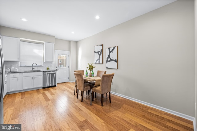 dining room with light wood-type flooring and sink