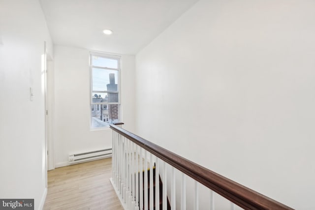 hall featuring a baseboard heating unit and light wood-type flooring