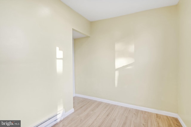 spare room with a baseboard heating unit and light wood-type flooring