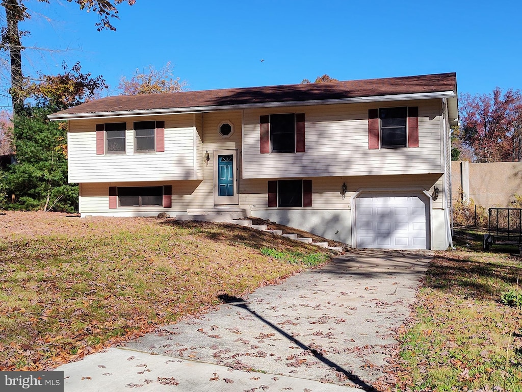 split foyer home featuring a front lawn and a garage