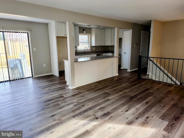 kitchen featuring hardwood / wood-style floors, white cabinets, and dark stone countertops