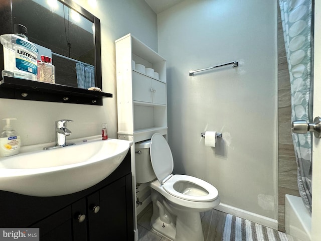 full bathroom with toilet, hardwood / wood-style flooring, vanity, and shower / bath combo with shower curtain