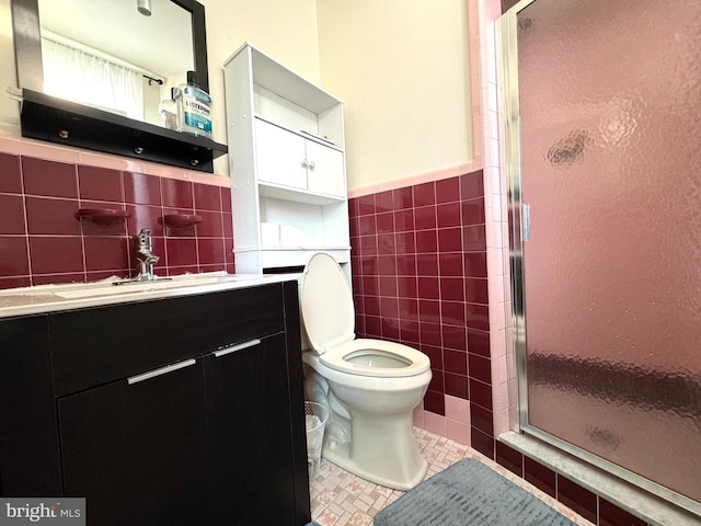 bathroom featuring vanity, toilet, tile walls, and an enclosed shower