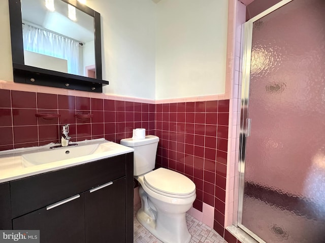 bathroom featuring wainscoting, toilet, a stall shower, and tile walls