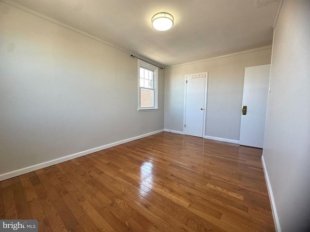 unfurnished bedroom with baseboards, ornamental molding, and wood finished floors