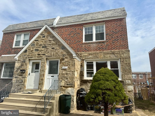 view of front of property featuring a high end roof and stone siding